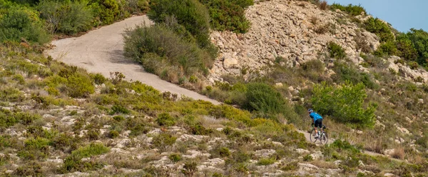 Onherkenbare fietser klimmend over hoge helling weg — Stockfoto