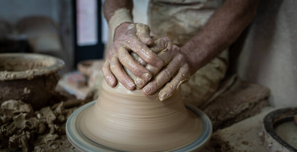Potter hands gently working on pottery, closeup view