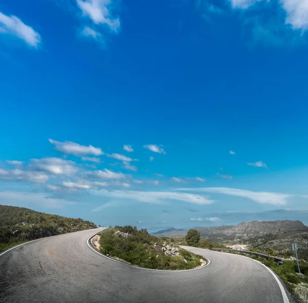 澄んだ青空の下でU字型の山道 — ストック写真