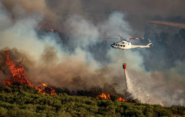 Helicopter with bambi bucket over the fire — Stock Photo, Image