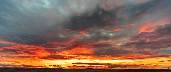 Coucher de soleil nuageux rouge profond avec chaîne de montagnes — Photo