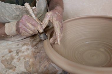 Potter, aletlerle esrar üzerinde usulca çalışıyor.