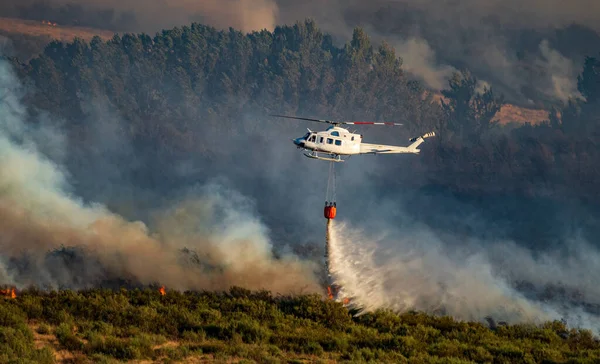 대나무 버킷을 사용하여 물을 화염 속으로 던지는 헬리콥터 — 스톡 사진