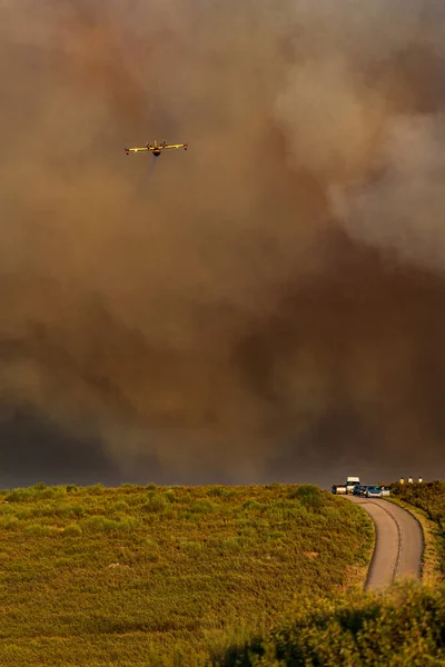 Захватывающий гидросамолёт пропускает воду над огромным пожарным дымом — стоковое фото