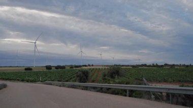 Yol, yel değirmenleri, üzüm bağları ve alacakaranlıkta bulut manzarası