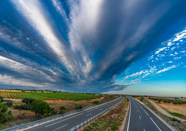 Autoroute, moulins à vent, vignobles et paysage nuageux au crépuscule — Photo