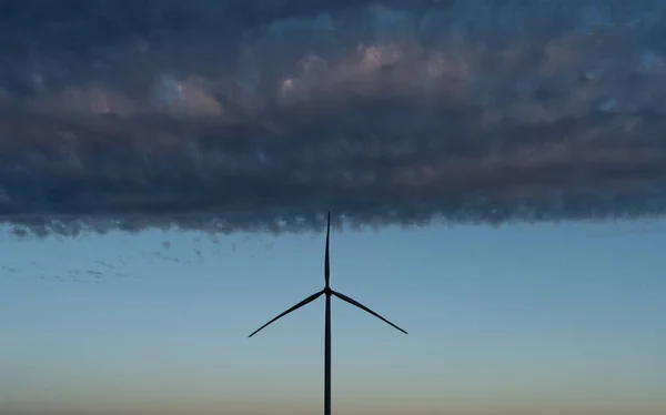 现代风车涡轮在云下的轮廓 — 图库照片