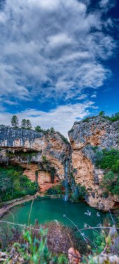 Şelale ve gölet dikey kayaların altında.