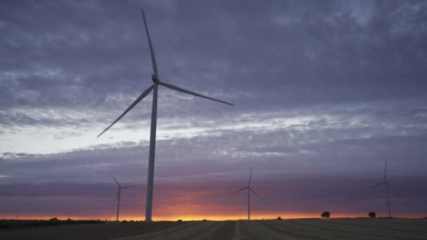 Pôr do sol com silhueta de turbinas eólicas modernas e paisagem nublada — Vídeo de Stock