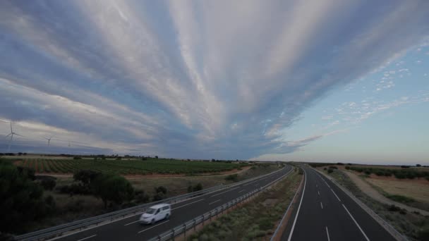 Autostrada z samochodami, wiatrakami i winnicami o zmierzchu — Wideo stockowe