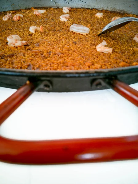 Spanish paella rice closeup view with red handle — Stock Photo, Image