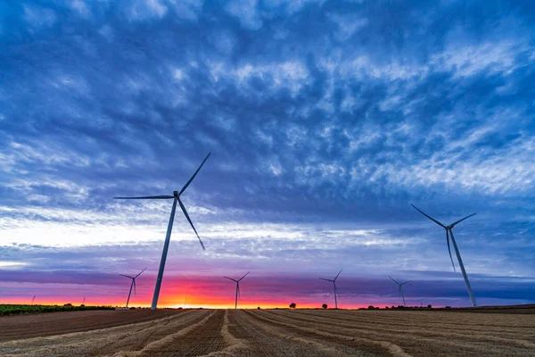 Modern windmills over cultivated fields at awe dusk — Stock Photo, Image