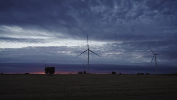Espectacular puesta de sol con nubes rápidas, cultivos y modernas turbinas eólicas que giran rápidamente — Vídeos de Stock