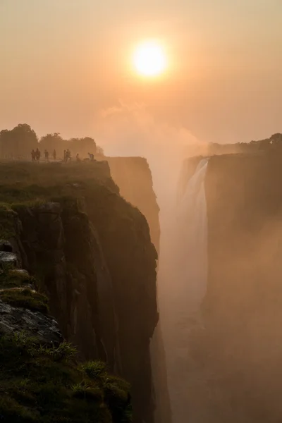 Victoria Falls sunset with tourist in the cliff — Stock Photo, Image