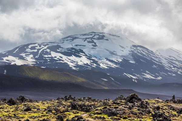 IJslandse vulkaan met sneeuw en bewolkte hemel — Stockfoto