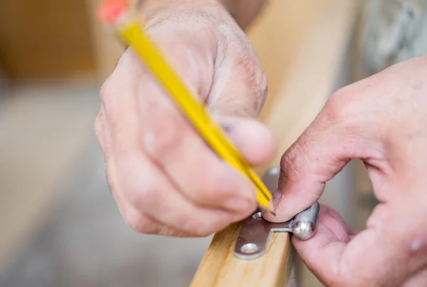 Closeup of carpenter with pencil working on door — Stock Photo, Image