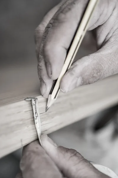 Sepia ton gros plan de charpentier avec crayon travaillant sur la porte — Photo