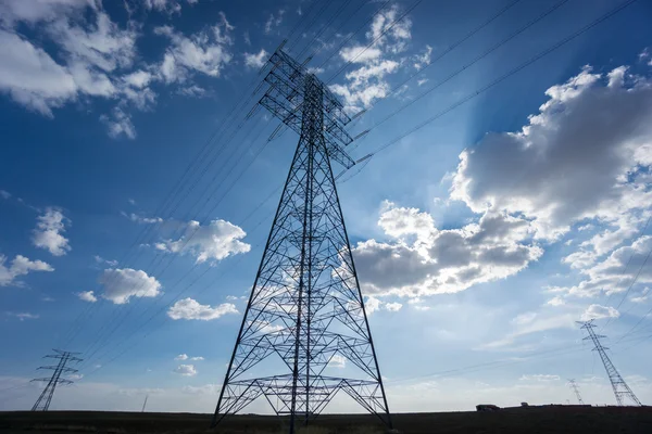 Mavi gökyüzü ve bulutlar üzerinde elektrik kulenin geniş açı — Stok fotoğraf