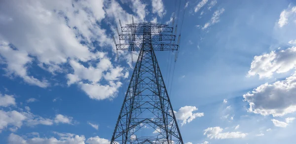 Torre elétrica centralizada sobre céu azul e nuvens — Fotografia de Stock