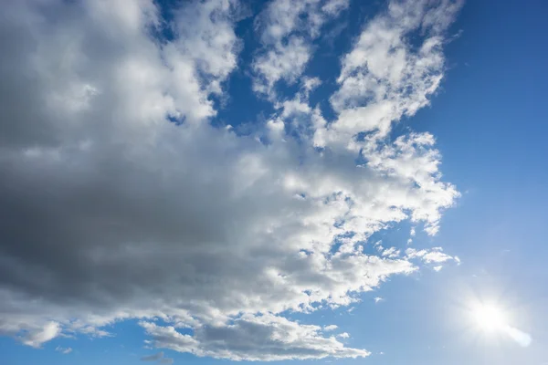 Grande nuvem sobre o céu azul com sol — Fotografia de Stock