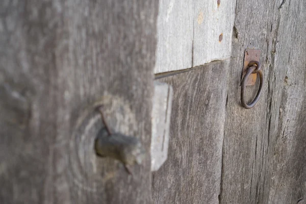 Old run-down wooden door and wooden lock out of focus — Stock Photo, Image