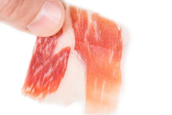 Bovenaanzicht van Kaukasische man hand nemen Serrano ham segment op wit — Stockfoto