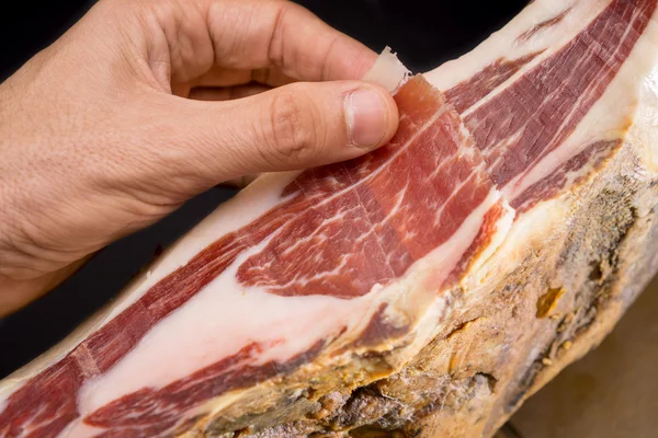 Vista dall'alto dell'uomo caucasico consegnare il prosciutto Serrano — Foto Stock