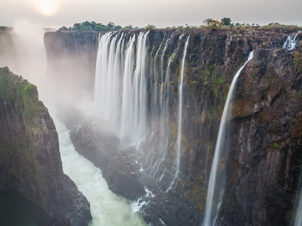 Coucher de soleil Victoria Falls, côté Zambie avec rivière zambezi, soleil rouge, longue exposition — Photo