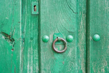 Eski, köhne yeşil, boyanmış ahşap kapı ve demir çiviler.