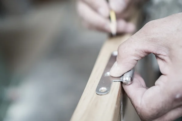 Closeup of carpenter hand with pencil working on door hinge — Stock Photo, Image