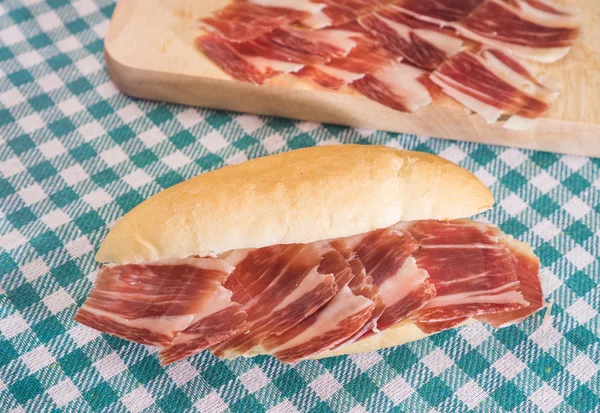 Sándwich de jamón serrano sobre mantel a cuadros — Foto de Stock