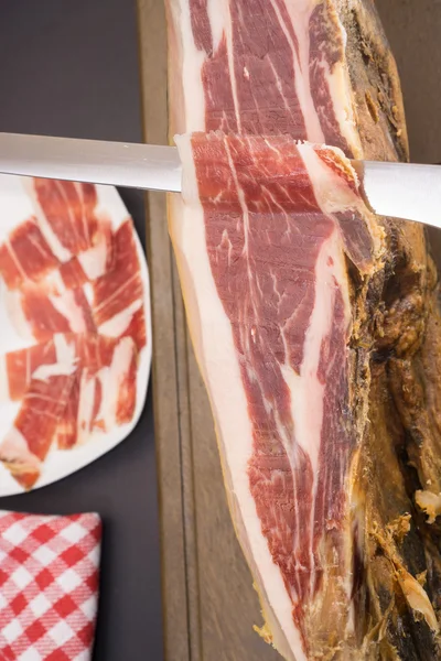 Top view of knife over Serrano ham, plate in the background — Stock Photo, Image