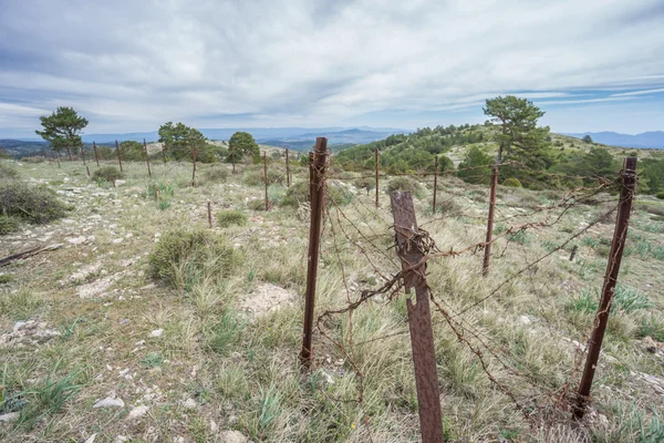 Abandoned military zone with rusty spiked fence — Stock Photo, Image