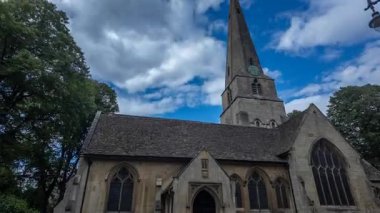 Zaman aşımı, dramatik ve hızlı hareket eden bulutların altında ünlü bir İngiliz gotik kilisesini ve mezarlığını gösteriyor..