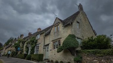 İngiltere 'deki ikonik Cotswold taş evleri bulutlu bir gökyüzü altında zamansız İngiliz mimarisini gözler önüne seriyor..