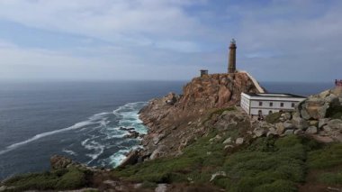 Galiçya 'daki Costa da Mortes dik Atlantik kayalıklarında bir deniz fenerinin sinematik çekimleri.