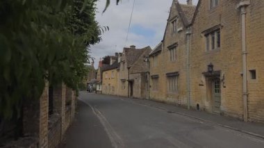 İngiliz Cotswolds 'daki güzel tarihi evlerle çevrili Bourton-on-the-Water' ın pitoresk taş caddelerinde yürüyorum..