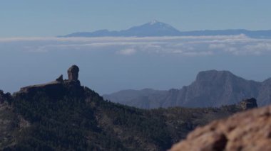 Gran Canaria 'da bulutların üzerinde yükselen Roque Nublo ve Pico de las Nieves' in durağan panoramik görüntüsü açık, güneşli bir günde.