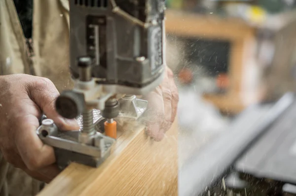 Blurred motion of carpenter working, preparing door for hinges — Stock Photo, Image