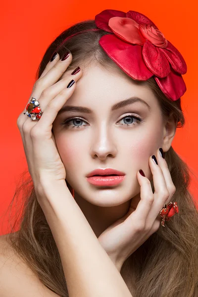 Menina bonita com flor vermelha na cabeça — Fotografia de Stock