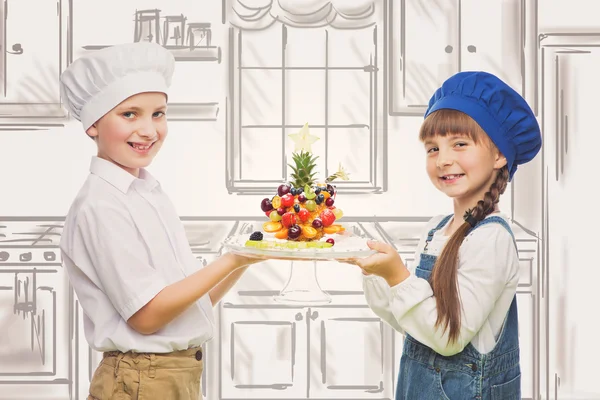 Niños sosteniendo bocadillo de fruta en forma de árbol — Foto de Stock
