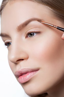 Woman correcting eyebrows form clipart