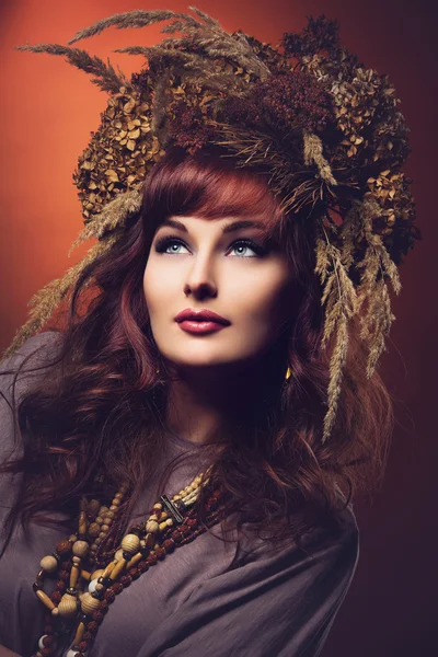 Mooie jonge vrouw met droge bloemen op hoofd — Stockfoto