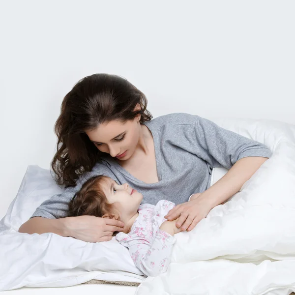 Güzel anne ve kızı yatakta — Stok fotoğraf