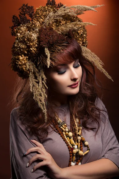 Schöne junge Frau mit trockenen Blumen auf dem Kopf — Stockfoto