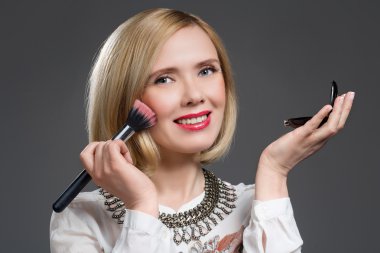 Güzel orta yaşlı kadın allık uygulayarak