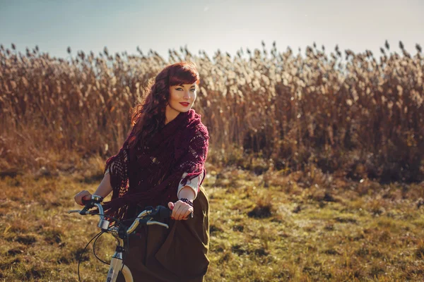 Красивая девушка катается на велосипеде в поле — стоковое фото