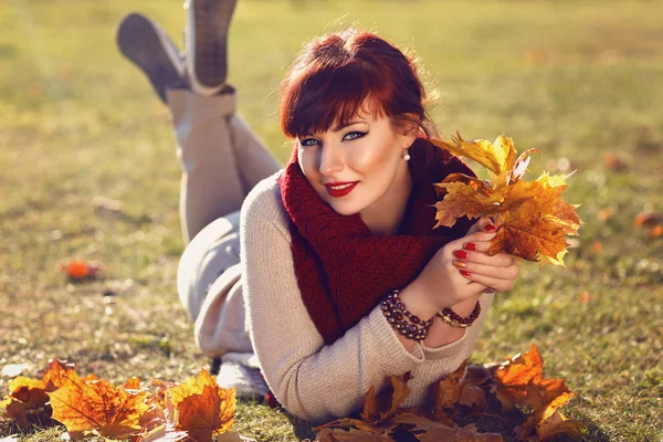 Mädchen liegt mit gelben Blättern auf dem Boden — Stockfoto