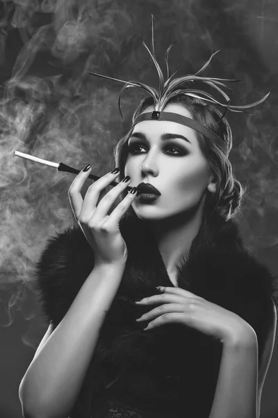 Belle fille aux yeux fumés et aux lèvres rouges tenant la cigarette — Photo