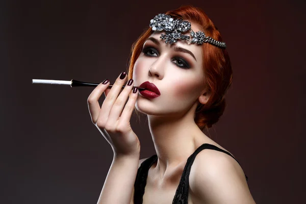 Gyönyörű lány füstös szemek és vörös ajkak cigaretta tartó — Stock Fotó